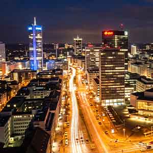 Moderne Skyline von Essen bei Nacht mit beleuchteten Hochhäusern und Straßenbeleuchtung, ideal für Escort Service Werbung in Essen.