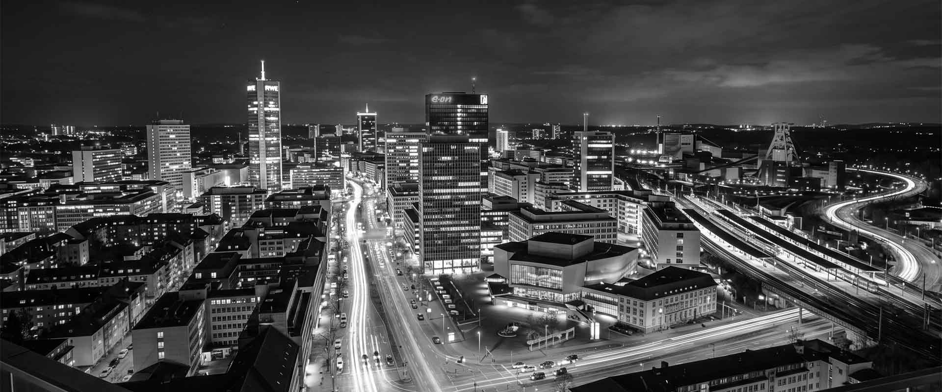 Moderne Stadt bei Nacht mit beleuchteten Gebäuden und Straßen, ideal für Escort Service Werbung.