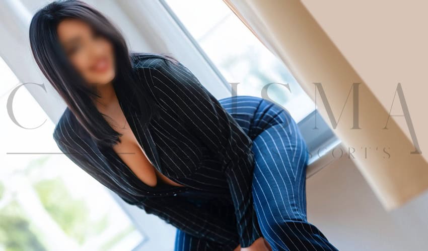 Attraktive Escort-Dame in eleganter Business-Kleidung, die Kundinnen und Kunden für eine diskrete Begleitung empfängt. Perfekt für exklusive Treffen und anspruchsvolle Ansprüche im Escort Service.